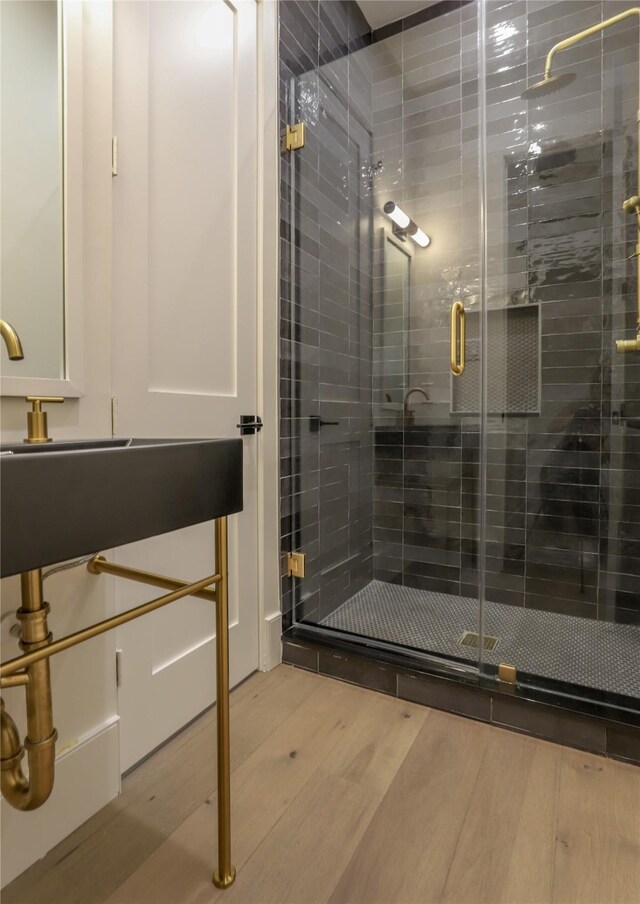 bathroom with an enclosed shower and hardwood / wood-style floors