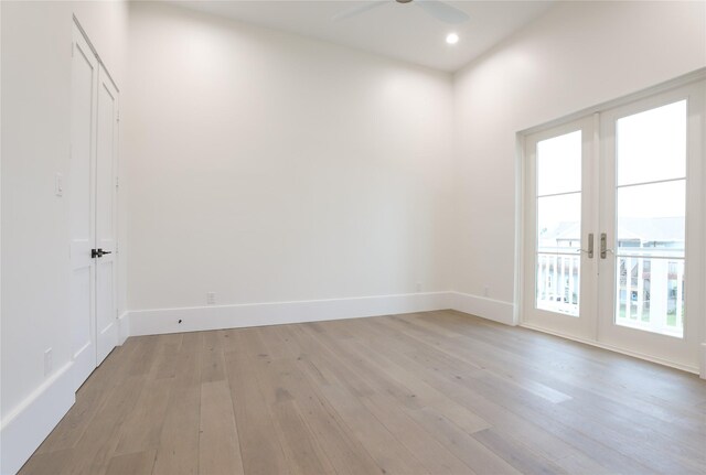 empty room featuring french doors, ceiling fan, a healthy amount of sunlight, and light hardwood / wood-style floors