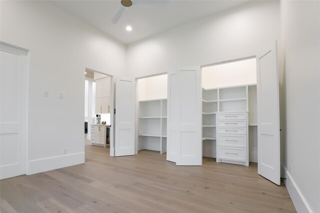 unfurnished bedroom featuring a spacious closet, ceiling fan, and light hardwood / wood-style flooring