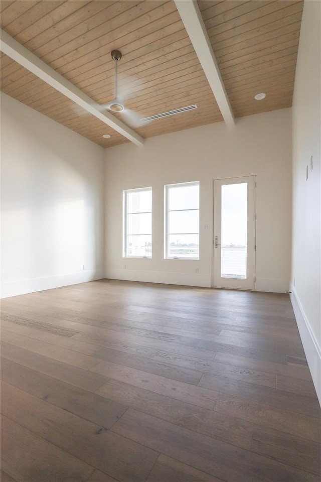 spare room featuring ceiling fan, dark hardwood / wood-style floors, wooden ceiling, and beamed ceiling