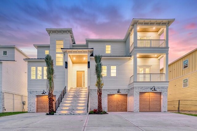 view of front of property featuring a balcony and a garage