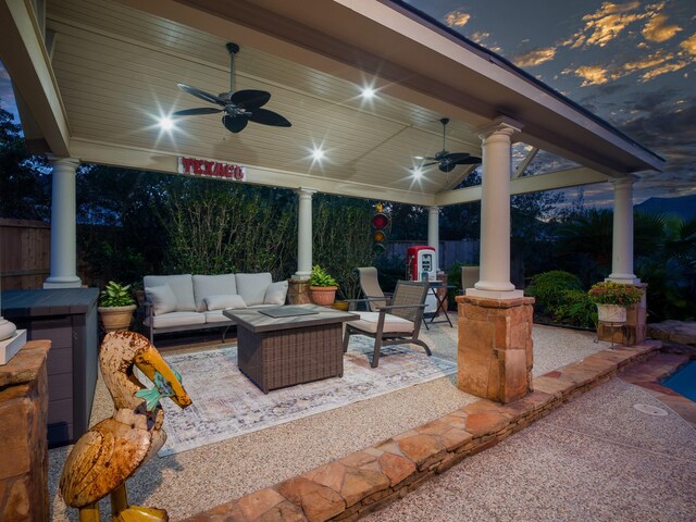 patio terrace at dusk with ceiling fan and an outdoor living space with a fire pit