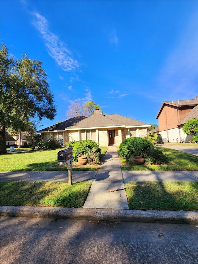 ranch-style home with a front lawn