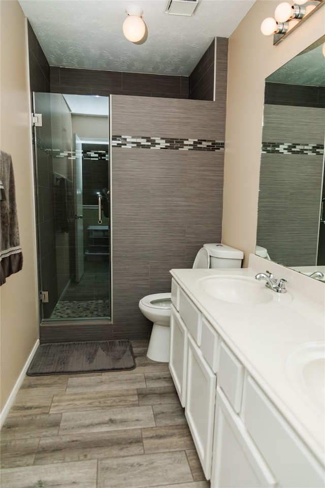 bathroom with toilet, walk in shower, and vanity