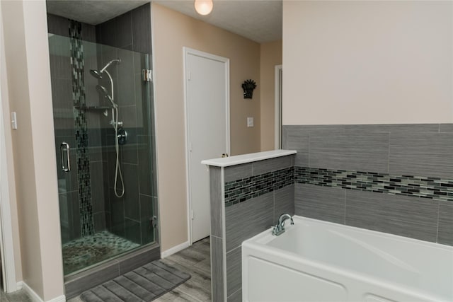 bathroom featuring shower with separate bathtub and wood-type flooring