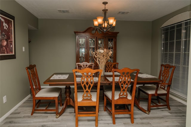 dining area featuring light wood-type flooring and a chandelier