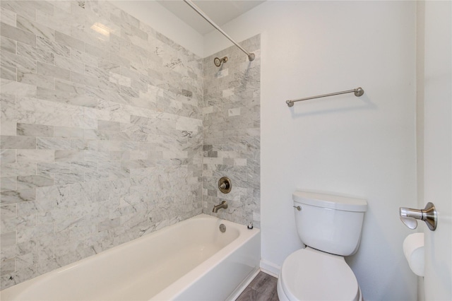 bathroom with hardwood / wood-style flooring, toilet, and tiled shower / bath