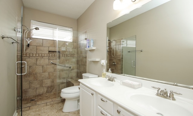 bathroom with tile patterned flooring, vanity, toilet, and a shower with shower door