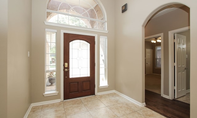 tiled entrance foyer with a healthy amount of sunlight