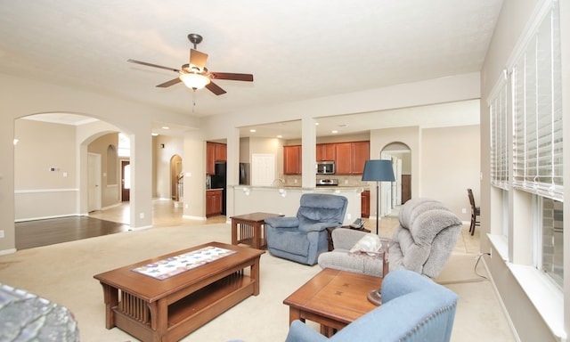 carpeted living room with ceiling fan