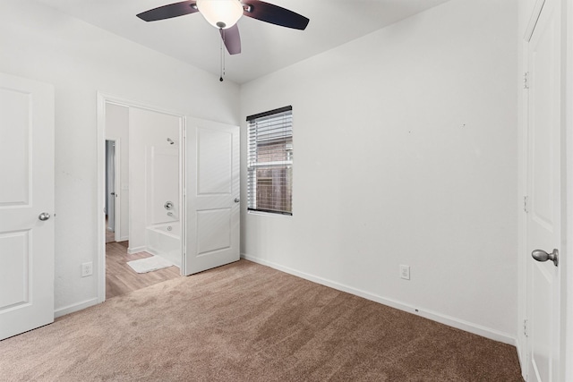 unfurnished bedroom featuring ceiling fan, light colored carpet, and connected bathroom