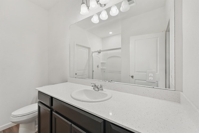 bathroom featuring toilet, hardwood / wood-style flooring, a shower, and vanity