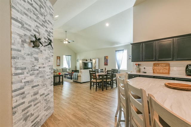 kitchen featuring high vaulted ceiling, ceiling fan, a wealth of natural light, and light hardwood / wood-style flooring