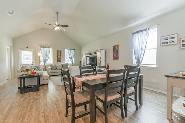 dining area with ceiling fan, vaulted ceiling, and light hardwood / wood-style flooring