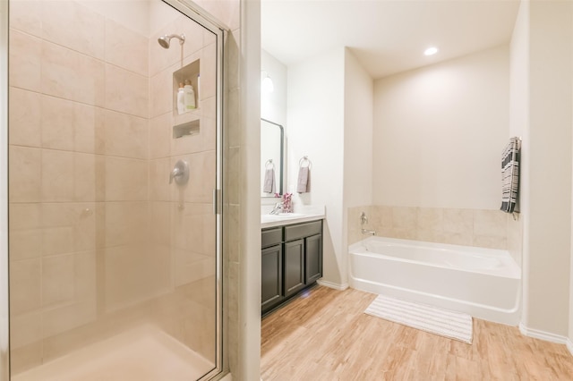 bathroom with vanity, wood-type flooring, and shower with separate bathtub