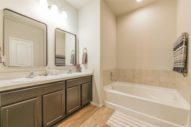 bathroom featuring a tub, vanity, and wood-type flooring