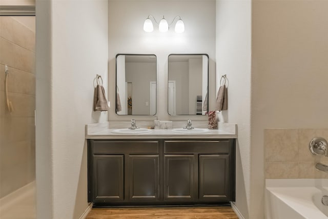 bathroom with a washtub, vanity, and hardwood / wood-style flooring