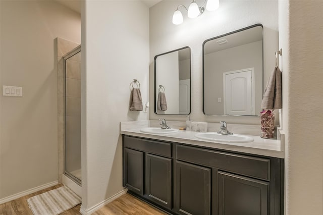 bathroom with walk in shower, vanity, and hardwood / wood-style flooring