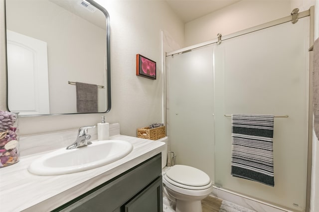 bathroom with vanity, toilet, and walk in shower