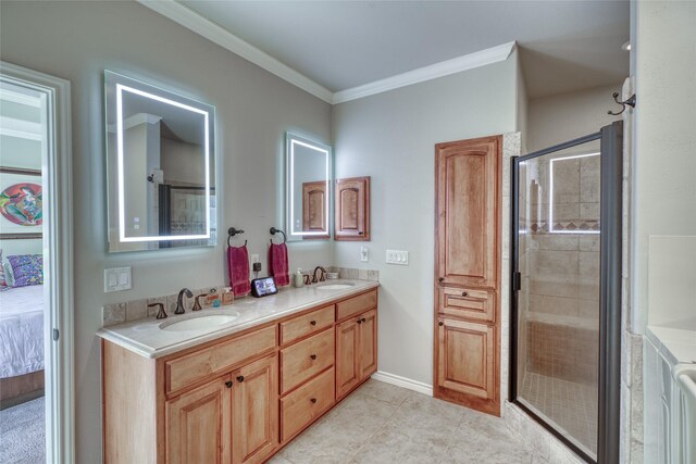 bathroom featuring tile patterned floors, vanity, a shower with shower door, and ornamental molding