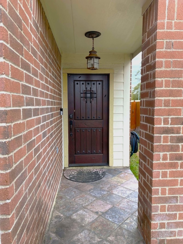 doorway to property featuring brick siding