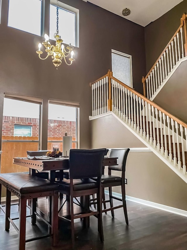 dining space featuring plenty of natural light, a notable chandelier, stairway, and wood finished floors