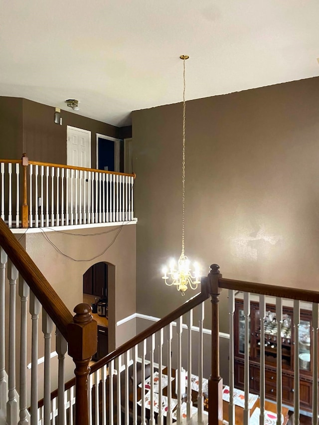 stairs featuring a notable chandelier