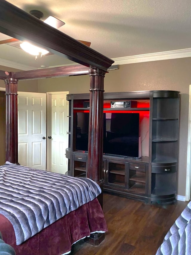 bedroom featuring decorative columns, ceiling fan, wood finished floors, a textured ceiling, and crown molding