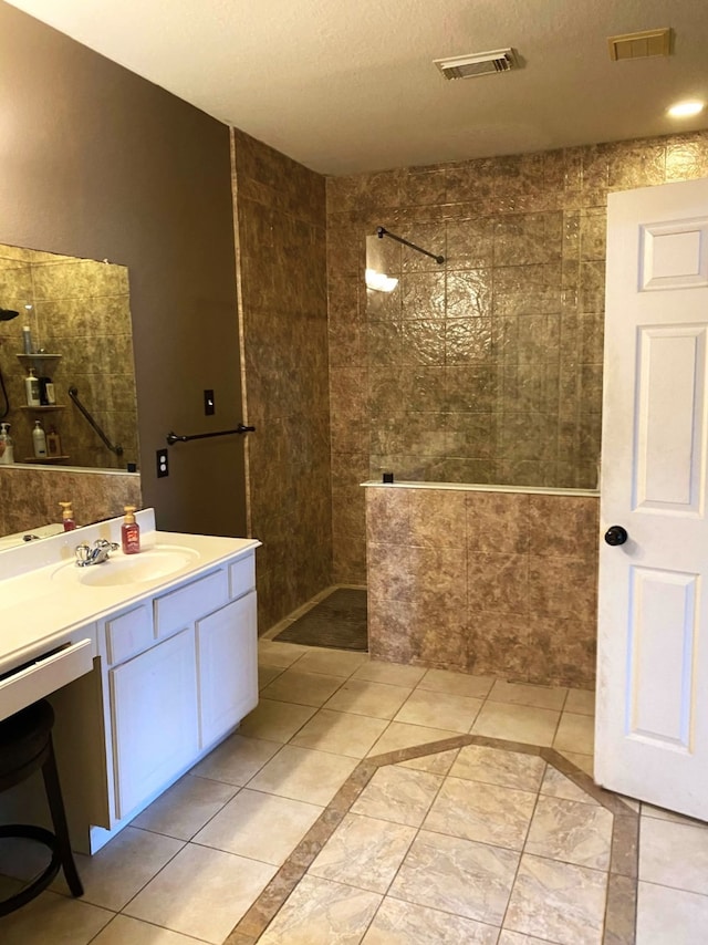 bathroom with visible vents, vanity, and walk in shower