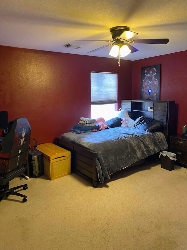 carpeted bedroom featuring ceiling fan, visible vents, and a textured ceiling