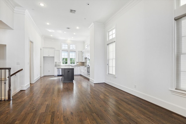 unfurnished living room featuring sink, ornamental molding, and dark wood-type flooring