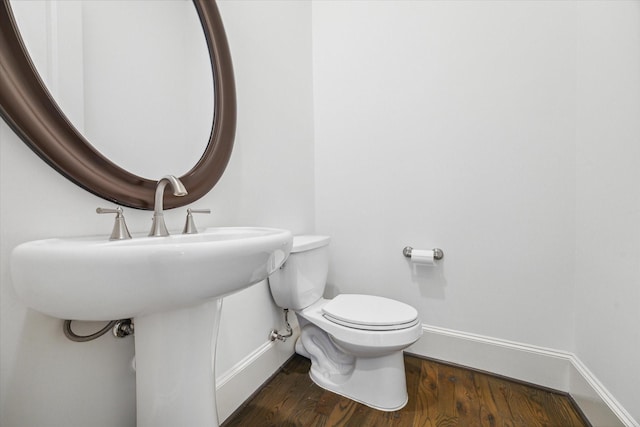 bathroom with toilet and wood-type flooring