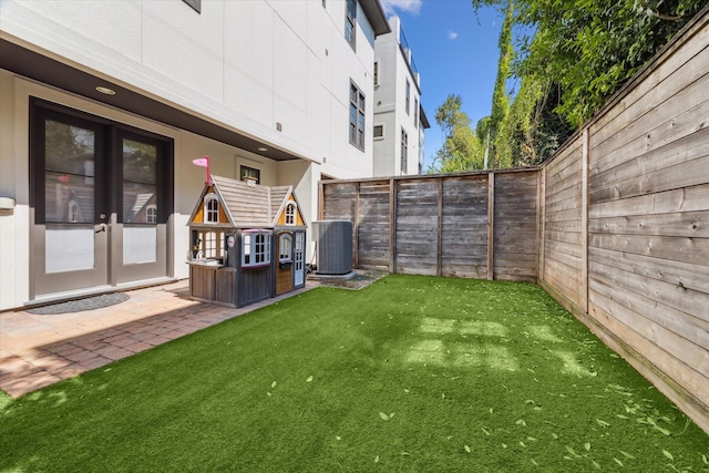 view of yard with a patio area, french doors, and central AC