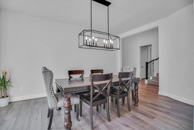 dining space with an inviting chandelier and light hardwood / wood-style flooring