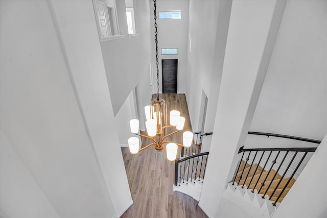 staircase featuring hardwood / wood-style flooring and a notable chandelier