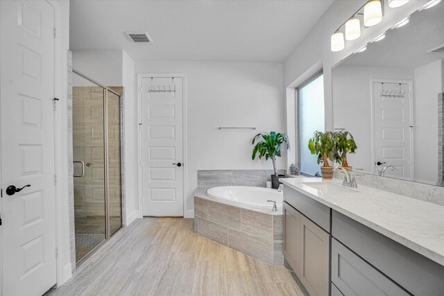 bathroom with shower with separate bathtub and vanity