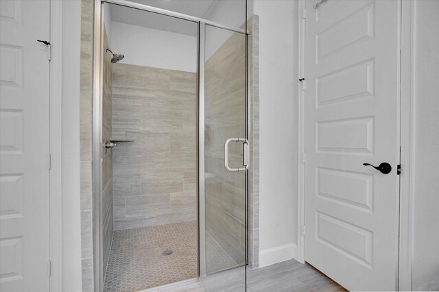 bathroom with an enclosed shower and hardwood / wood-style floors