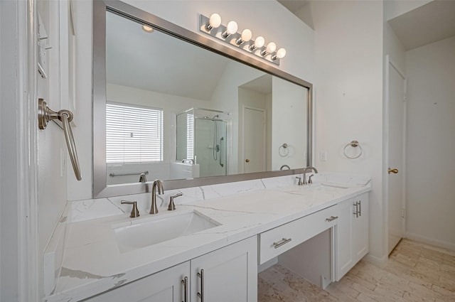 bathroom featuring double vanity, a stall shower, and a sink