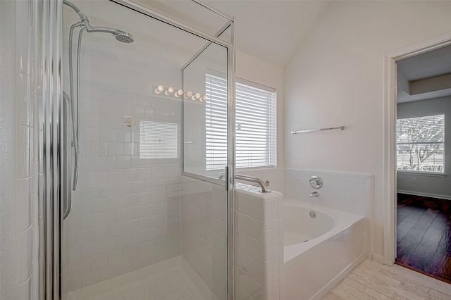 full bath featuring a garden tub, a shower stall, and a wealth of natural light