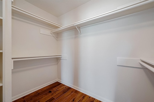 spacious closet with dark wood-style floors