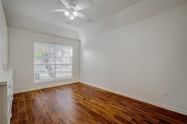 unfurnished room with dark wood-type flooring, a ceiling fan, and baseboards