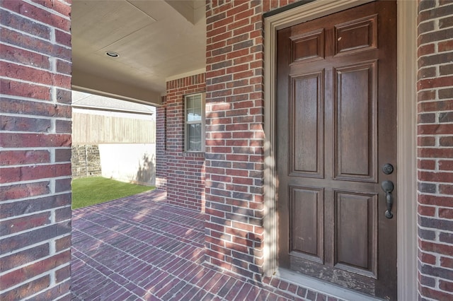 property entrance featuring brick siding