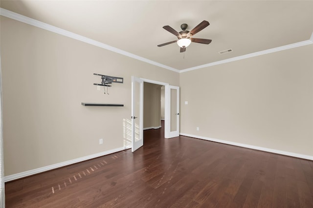 spare room with baseboards, visible vents, ceiling fan, dark wood-type flooring, and crown molding