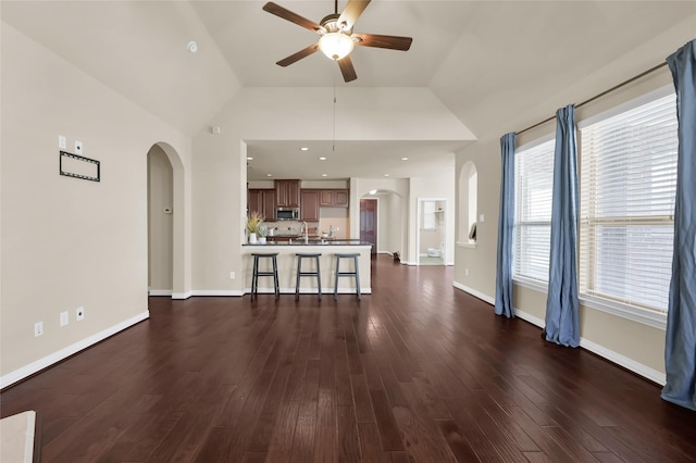 unfurnished living room featuring ceiling fan, lofted ceiling, and dark hardwood / wood-style floors