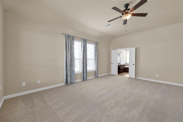 unfurnished room featuring lofted ceiling, ceiling fan, light colored carpet, visible vents, and baseboards