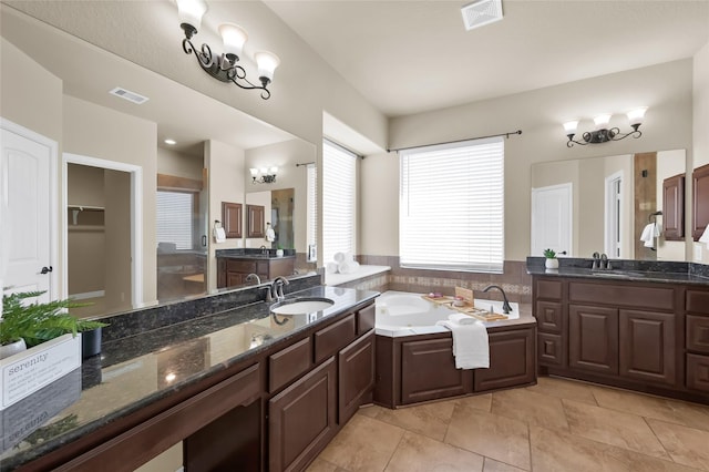 bathroom featuring vanity, a bath, and tile patterned flooring