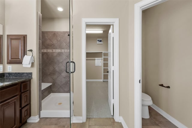 bathroom with tile patterned floors, vanity, toilet, and an enclosed shower