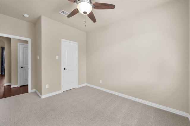 unfurnished bedroom with a ceiling fan, dark carpet, visible vents, and baseboards