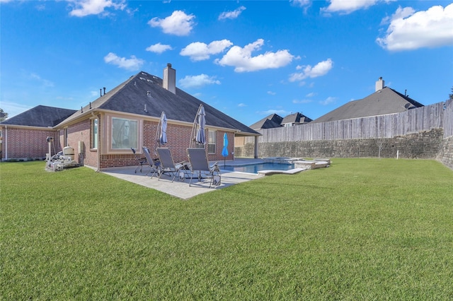 back of house with a fenced in pool, a yard, and a patio area