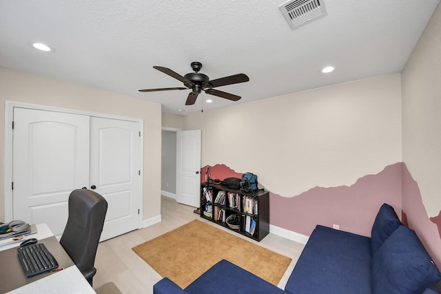 home office featuring ceiling fan, a textured ceiling, and light hardwood / wood-style flooring